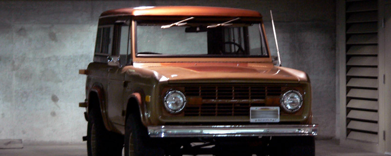 Fotograma de Lost: un Ford Bronco antiguo, de color cobrizo, aparcado en un garaje de hormigón.